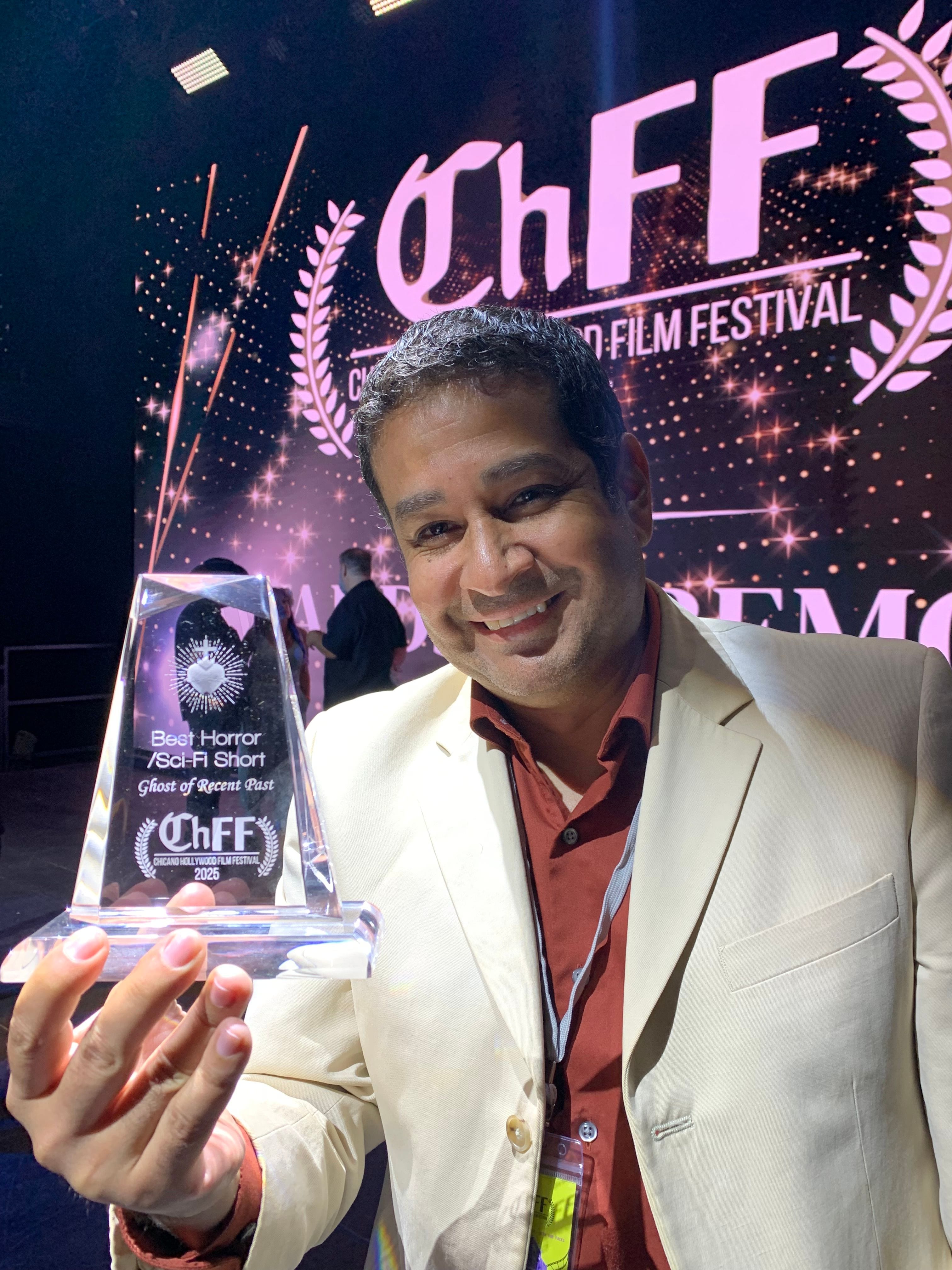 A filmmaker holds the 2025 Chicano Hollywood Film Festival Best Horror/Sci-Fi Short award for Ghost of Recent Past.